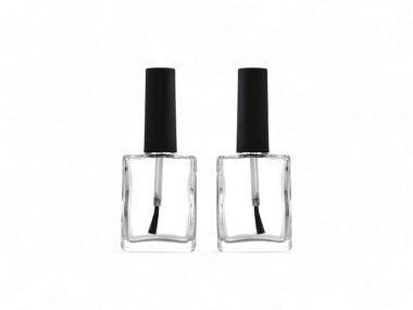 Bir çift boş kare cam tırnak cilası şişeleri ve siyah kapaklar.