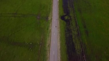 Dağın yakınındaki bir tarlada arabanın sürdüğü yol boyunca uçuyor.