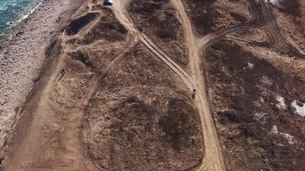 Vídeo aéreo de un ciclista montando una bicicleta de montaña en un camino de tierra en Rusia — Vídeo de stock