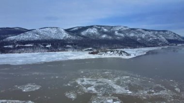 Buzlu bir nehrin ve kışın Amerika 'da Appalachian sıradağlarındaki karla kaplı dağların insansız hava aracı görüntüleri taze kar yağışı sonrasında. Burası Hudson Vadisi 'ndeki Hudson Nehri.. 