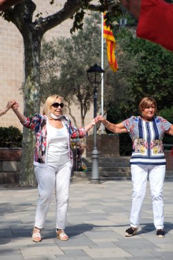 Katalanca dans eden iki yaşlı kadın, Katalonya Ulusal Günü 'nde Arenys de Munt (Barselona) adlı bir kasabanın ana meydanında dans ederler.).