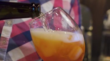 Kafedeki barmen, bardağa alkollü aperol spreyine şampanya döker.