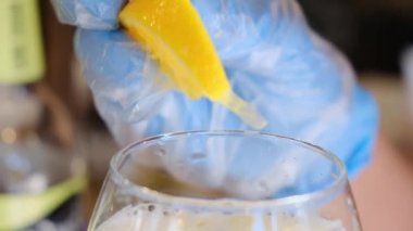 Barmen hazır alkollü bir kokteyli portakal dilimleriyle süslüyor.