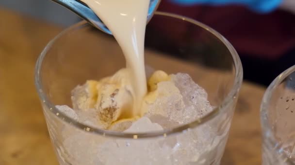 Bartender pours an alcoholic cocktail baileys frappe from blender into glass — Vídeo de Stock