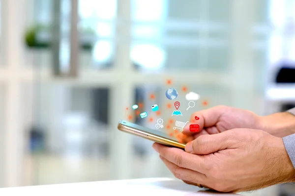 A businessman holding a smartphone and surfing the internet and networking social media. Surfing internet concept.