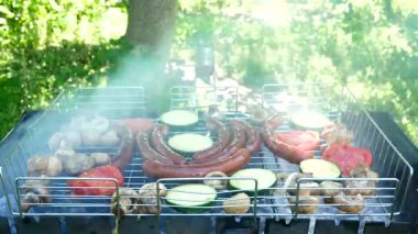 Sausages and grilled vegetables on the grill, outdoors. Grilled food, barbecue. Close-up