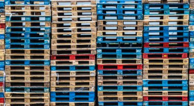 Sıraya dizilmiş farklı renklerde ahşap avro paletleri, soyut arkaplan