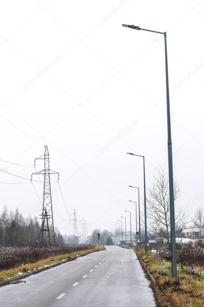 Street with led street lamps alongside and powerline on oposite side