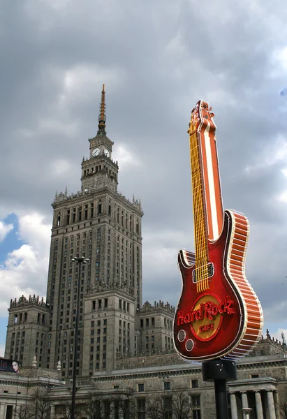 "Hard Rock Cafe "guitarra como símbolo da cultura ocidental e" Palácio da Cultura e Ciência "como símbolo da era do comunismo, centro da cidade de Varsóvia, Polônia — Fotografia de Stock