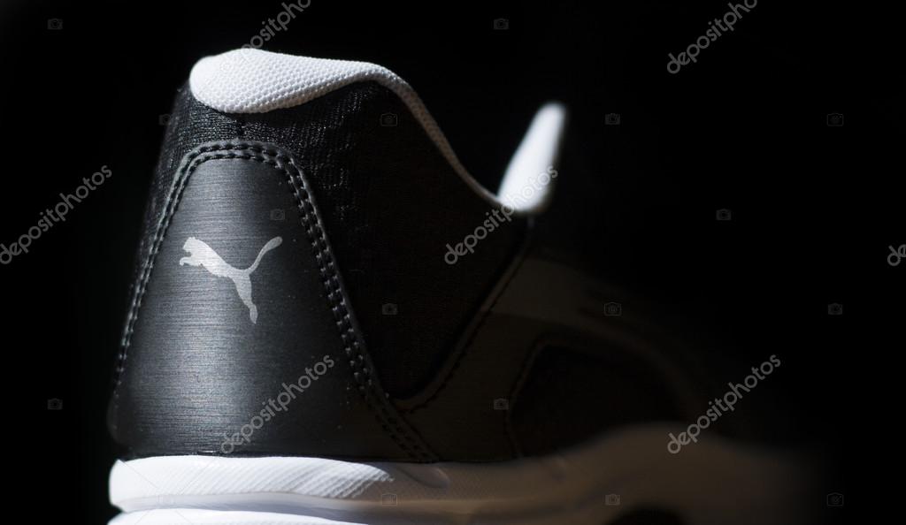 Puma Logo on back of black sport shoe on black background
