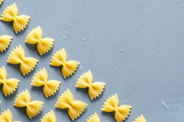Açık mavi arkaplanda Farfalle makarna deseni. 