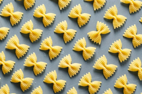 Açık mavi arkaplanda Farfalle makarna deseni. 