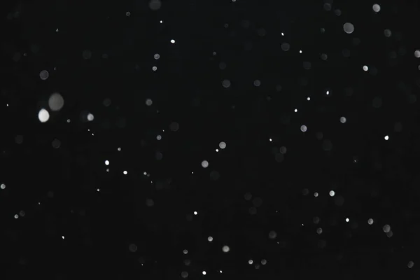 Nieve iluminada por un destello vuela en la oscuridad — Foto de Stock