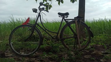 Kırsalda bir çiftçi tarafından kullanılan eski bir bisiklet, kırsal yaşamı, sadeliği ve geleneksel ulaşım cazibesini gösteriyor..