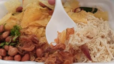 Bir kase sıcak bubur ayam dilimlenmiş tavuk, kraker ve lezzetli malzemelerle, kahvaltı ya da rahatlatıcı bir yemek için mükemmel olur..