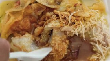 Bir kase sıcak bubur ayam dilimlenmiş tavuk, kraker ve lezzetli malzemelerle, kahvaltı ya da rahatlatıcı bir yemek için mükemmel olur..