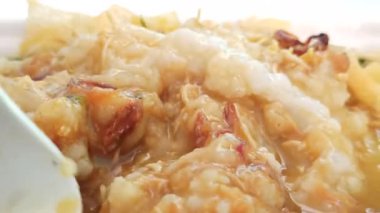 Bir kase sıcak bubur ayam dilimlenmiş tavuk, kraker ve lezzetli malzemelerle, kahvaltı ya da rahatlatıcı bir yemek için mükemmel olur..