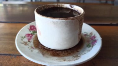 Klasik tarzda servis edilen bir bardak sade kahve, güçlü bir aroma ve basit bir sıcaklık sunuyor, sakin bir rahatlama anı ve geleneksel kahve keyfi için mükemmel..