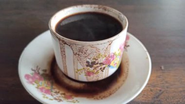 Klasik bir bardakta servis edilen koyu bir fincan, zengin bir aroma ve basit bir geleneksel stil, rahatlatıcı bir an ve günlük rutin için mükemmel..