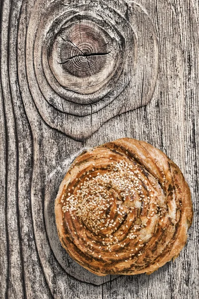 Pasta de sopro rolo de gergelim no fundo de madeira de nós rachado velho — Fotografia de Stock