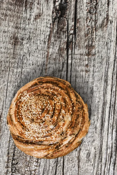 Pasta de sopro Rolo de gergelim em fundo de madeira rachada velha — Fotografia de Stock