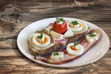 Bacon Cheese Egg Ham and Tomato Sandwich on old Wooden Table