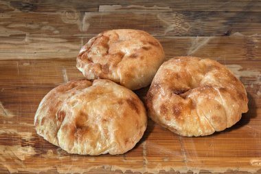 Three Pita Bread Loafs on Old Wooden Table