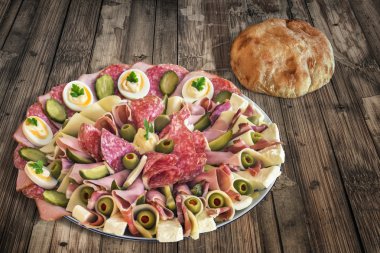 Plateful of Serbian Appetizer Meze with Pita Bread and Tomato on very old Wooden Table