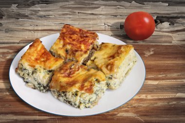 Plate of Serbian Cheese Spinach Pie Zeljanica Slices with Tomato