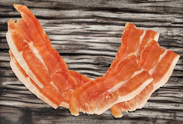 Gerookte varkensvlees Ham Prosciutto segmenten op zeer oude houten oppervlak — Stockfoto