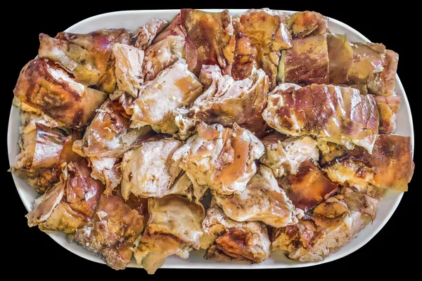 Spit Roasted Pork Slices on Porcelain Oblong Platter Isolated on Black Background