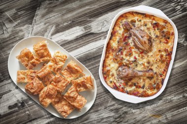 Tavuk etli sebze güveç ve Gibanica peynir pasta dilimler halinde plakalı eski ahşap Bahçe masa yüzeyi