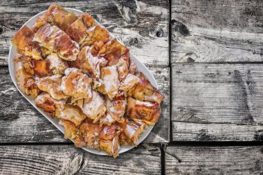 Plateful of Spit Roasted Pork Slices on Old Weathered Wooden Floorboards Surface clipart