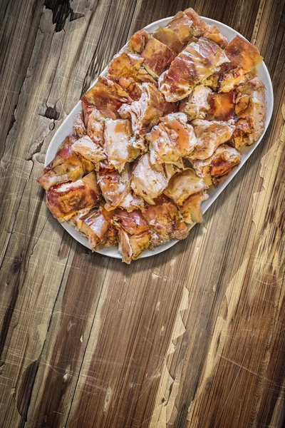 Plateful of Spit Roasted Pork Slices on Old Cracked Peeled Wooden Surface — Stock Photo, Image