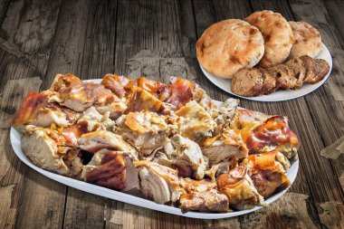 Tabak dolusu tükürük domuz baget ayrılmaz ekmek dilimleri ile kavrulmuş ve pide üzerinde eski ahşap masa Loafs