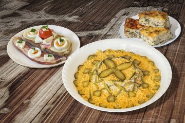 Rus salatası Pastırmalı yumurta ve peynirli sandviç ve ıspanak peynir pasta Zeljanica eski ahşap tablo