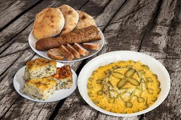 Ensalada rusa con pan y tarta de queso de espinacas en una mesa de madera vieja agrietada — Foto de Stock