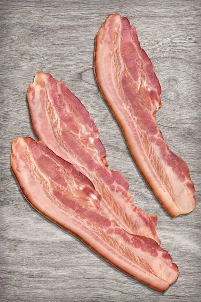 Rashers de bacon de porco em pano de fundo de madeira branqueada — Fotografia de Stock