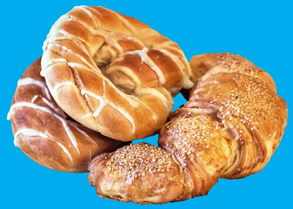 Pretzels y Croissant Puff pastelería espolvoreada con semillas de sésamo, aislado sobre fondo azul — Foto de Stock