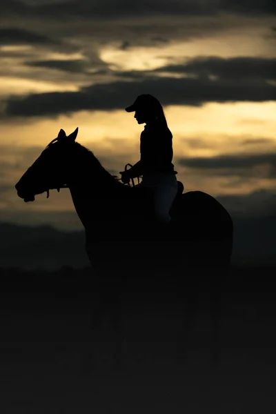 女性は山の背景の中庭で馬に乗って空と日没 屋外風景 写真ストック — ストック写真