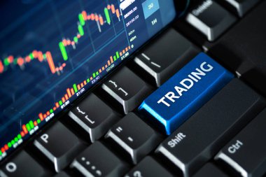 Klavye bilgisayarı ve mavi alım satım düğmesi üzerindeki borsa grafikleri, online yatırım kavramı
