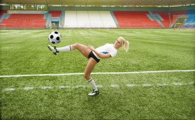 Kız futbol oynuyor.