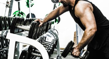 Adam ağırlık kaldırıyor. 