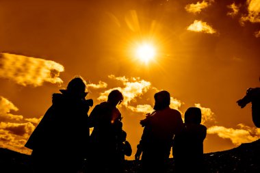 Tepe üzerinde duran fotoğrafçıların siluetleri