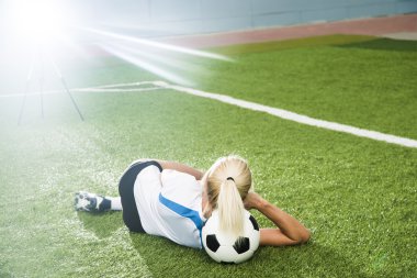 Young football girl lie on ball clipart