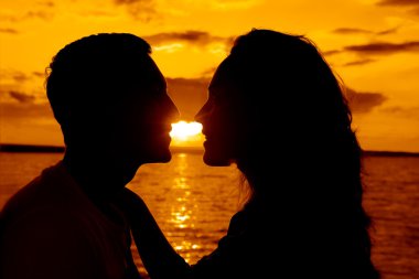 Genç bir çift sahilde öpüşme silüeti 