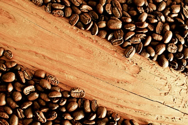 Grãos de café na superfície de madeira — Fotografia de Stock