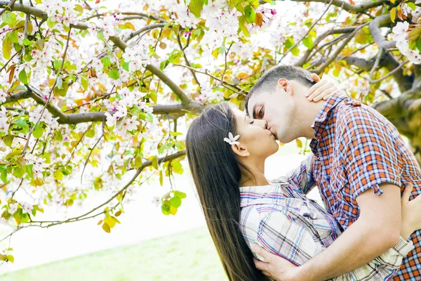 開花枝の下で愛のカップル 若い大人ブルネット アジア男と女の新鮮なリンゴの木の下でキス — ストック写真