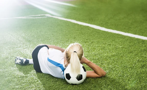 Jovem menina de futebol mentira na bola — Fotografia de Stock