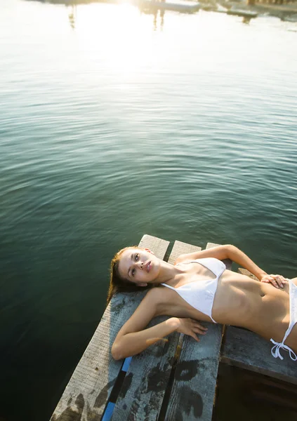 Bella ragazza sdraiata sul molo — Foto Stock